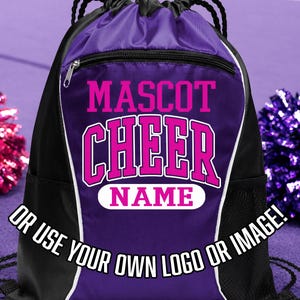 Può includere: Uno zaino con coulisse nero e viola con una tasca frontale con cerniera. La borsa presenta le parole "MASCOT CHEER NAME" in lettere rosa. Il testo "OR USE YOUR OWN LOGO OR IMAGE!" è stampato in basso.
