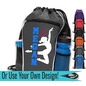 Puede incluir: Mochila negra con cordón y ribete blanco, un bolsillo lateral y una botella de agua azul. La mochila presenta el nombre "MEGAN" en azul, un corazón y una silueta de gimnasta. El texto "Or Use Your Own Design!" está en la parte inferior.
