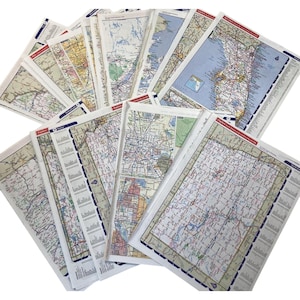 May include: A collection of folded road maps, featuring detailed depictions of roads, cities, and geographical features. The maps display a variety of colors and are arranged in a fan-like pattern. The maps are from the Explore series.