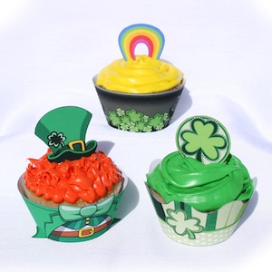 May include: Three decorated cupcakes with green, orange, and yellow frosting. The cupcakes are topped with a rainbow, a leprechaun hat, and a shamrock.