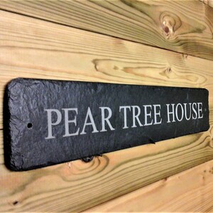 May include: Black slate house sign with the text "PEAR TREE HOUSE" in white lettering.