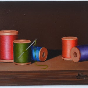 May include: Still life painting of five spools of thread on a wooden surface. The spools are red, green, blue, and purple. A needle is threaded through the green spool.