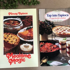 May include: Two vintage cookbooks with the "Minute Tapioca" brand. The left book is titled "Mealtime Magic" and features images of various dishes. The right book is titled "Tap into Tapioca" and shows a pie and layered desserts.