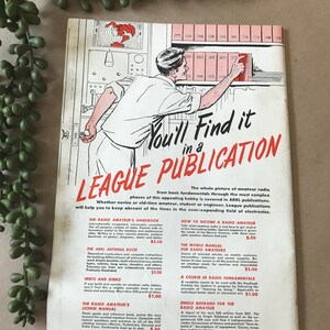 May include: Vintage magazine cover for the American Radio Relay League. The cover features a man reaching for a book on a shelf, with the title "You'll Find it in a League Publication" in red and white. The magazine is a guide for amateur radio enthusiasts.