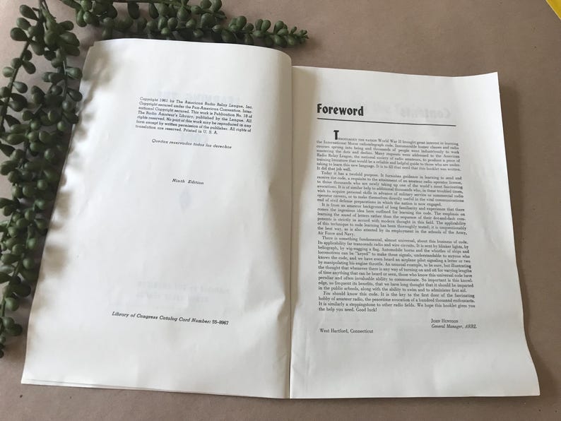 May include: An open book with the title "Foreword" on the right page. The left page has text and the words "Ninth Edition." Green leafy sprigs are in the upper left corner.