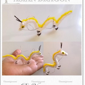 May include: Amigurumi pattern for an Asian dragon, a crocheted white and yellow dragon with black horns. The pattern is by Vinamigurumi.