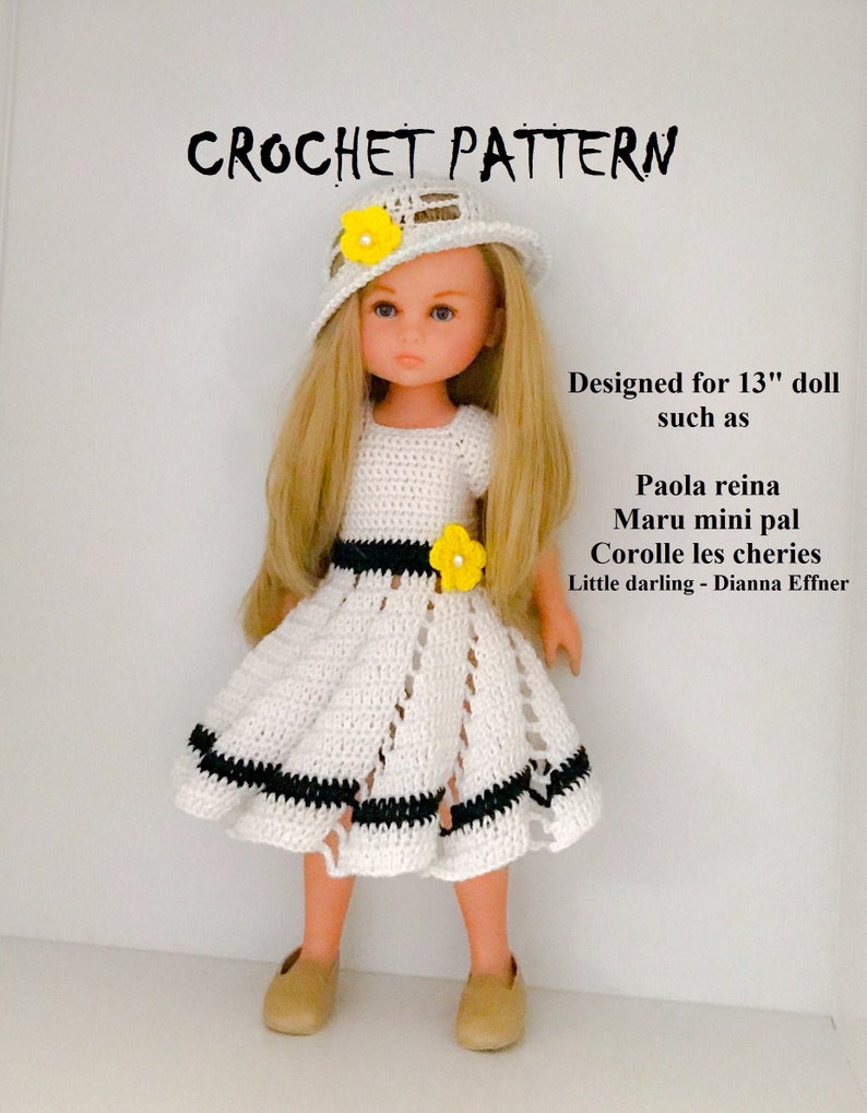 May include: Crochet pattern for a 13-inch doll, featuring a white dress with black trim and a white crocheted hat with a yellow flower. The doll has blonde hair and blue eyes. Designed for dolls such as Paola Reina, Maru mini pal, Corolle les cheries, and Little darling - Dianna Effner.
