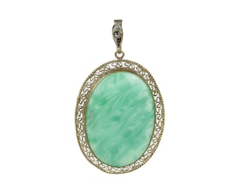 May include: A silver oval pendant with a green stone set in a filigree design.