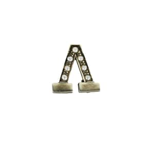 Könnte beinhalten: Eine silberne Brosche in Form des Buchstabens 'A' mit einer Reihe weißer Perlen auf jeder Seite.