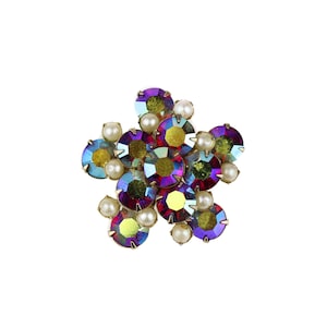 May include: A flower-shaped brooch with iridescent purple, red, and green rhinestones and white pearl accents.