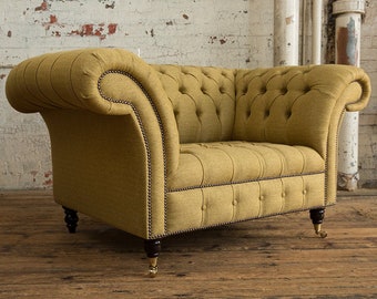 May include: A mustard yellow tufted armchair with wooden legs and brass casters. The chair is upholstered in a textured fabric and has a classic design.