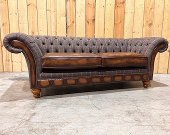 May include: A brown leather and tweed chesterfield sofa with tufted upholstery and wooden legs.