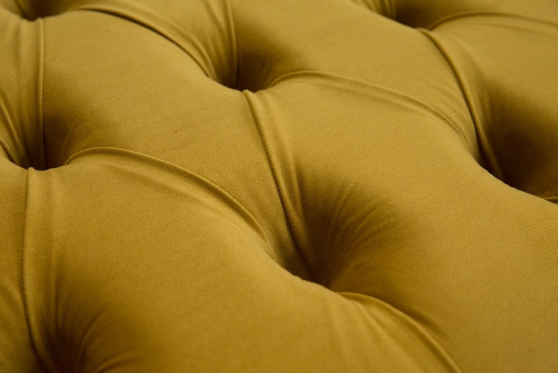 Puede incluir: Primer plano de una tela capiton&eacute; de color amarillo mostaza con un patr&oacute;n de rombos. La tela es suave y mullida, con un brillo sutil.