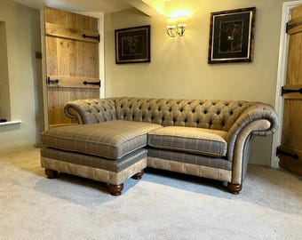 May include: A brown and tan tweed sectional sofa with a chaise lounge. The sofa has a tufted back and seat cushions. The sofa is sitting on a light brown carpet.