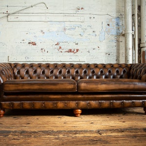 Sofá Chesterfield de 4 plazas, tradicional británico, hecho a mano, de cuero marrón antiguo.
