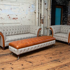 May include: A set of three gray and brown tufted sofas with wooden legs. The sofas are arranged in a living room setting with a wooden floor.