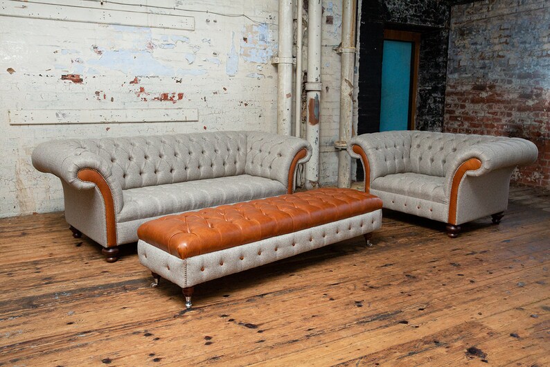 May include: A set of three gray and brown tufted sofas with wooden legs. The sofas are arranged in a living room setting with a wooden floor.
