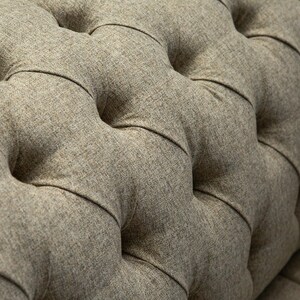 May include: Close-up of a brown tufted fabric with a buttoned design. The fabric has a textured, woven appearance.