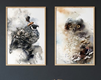 Puede incluir: Dos impresiones en acuarela enmarcadas de aves. Una presenta una codorniz con plumas negras, blancas y marrones. La otra representa un búho con ojos grandes y tonos suaves. Ambas están sobre una pared oscura.