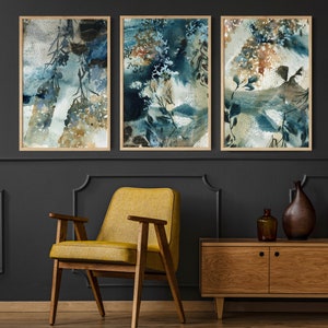K&ouml;nnte beinhalten: Drei gerahmte abstrakte Aquarelldrucke. Das Kunstwerk zeigt eine Mischung aus Blau-, Gr&uuml;n- und Beiget&ouml;nen mit botanisch inspirierten Formen. Die Rahmen sind hellbraun. Die Drucke werden &uuml;ber einem Holzschrank im modernen Stil aus der Mitte des Jahrhunderts ausgestellt.