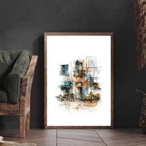 Op de afbeelding: Aquarel schilderij van een Europees gebouw met een balkon, blauwe luiken en een kleine luifel. Het kunstwerk is ingelijst in een lichtbruine houten lijst en wordt tentoongesteld op een donkere houten vloer. Het kleurenpalet omvat tinten bruin, blauw en oranje.