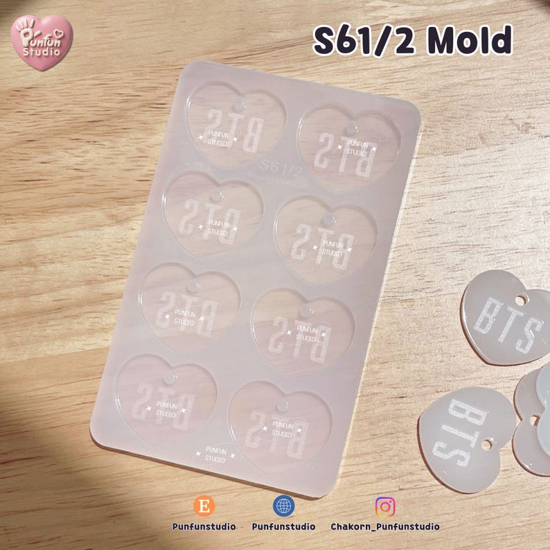 May include: A translucent silicone mold featuring eight heart-shaped cavities, each embossed with the text BTS and Punfun Studio. The mold is labeled S61/2 Mold at the top. Two finished heart-shaped charms with the text BTS are positioned to the right.