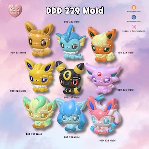 May include: A collection of nine small, stylized creature figurines labeled DDD 221 through DDD 229 Mold. The figures feature various colors including brown, blue, orange, yellow, black, pink, green, and multi-colored designs with large eyes.