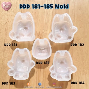 May include: Five translucent silicone molds labeled DDD 181-185. Four molds feature a cartoon dog character with pointed ears and rounded bodies. The central mold, DDD 185, is a small rounded shape with the text Home Sweet Home embossed inside.