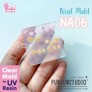 May include: Clear silicone mold for nail art featuring a variety of shapes, including hearts, stars, clouds, and lightning bolts. The mold is labeled "NA06" and is made for UV resin.