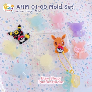 Może przedstawiać: Zestaw dziewięciu silikonowych form do tworzenia zawieszek z postaciami z anime. Formy są przezroczyste i pokazują wzory zawieszek, w tym Pikachu, Eevee, Squirtle, Bulbasaur, Charmander, Jigglypuff, Meowth, Psyduck i Snorlax. Formy znajdują się na białym tle z różowymi i niebieskimi kropkami. Na obrazku nadrukowany jest tekst "AHM 01-09 Mold Set" i "Anime Hanger Mold". Na obrazku nadrukowany jest również tekst "Etsy Shop: Punfunstudio".