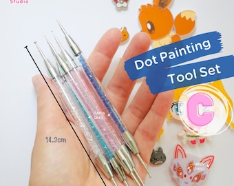 May include: Set of five dotting tools for nail art or painting. The tools are made of metal with clear handles that have glitter embedded in them. The tools are 14.3 cm long. The set is labeled "Dot Painting Tool Set C".