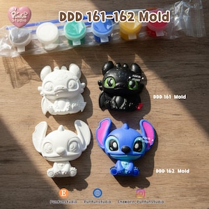 May include: A white ceramic mug with a black handle and the text "But First, Coffee" in a black, handwritten-style font. The mug is on a white surface.