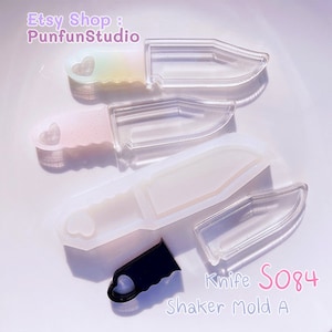 Könnte beinhalten: Eine Sammlung klarer, messerförmiger Shaker-Formen mit herzförmigen Griffen. Die Formen bestehen aus transparentem Kunststoff und sind auf einer weißen Oberfläche angeordnet. Der Text "Etsy Shop: PunfunStudio" und "Knife S084 Shaker Mold A" sind sichtbar.