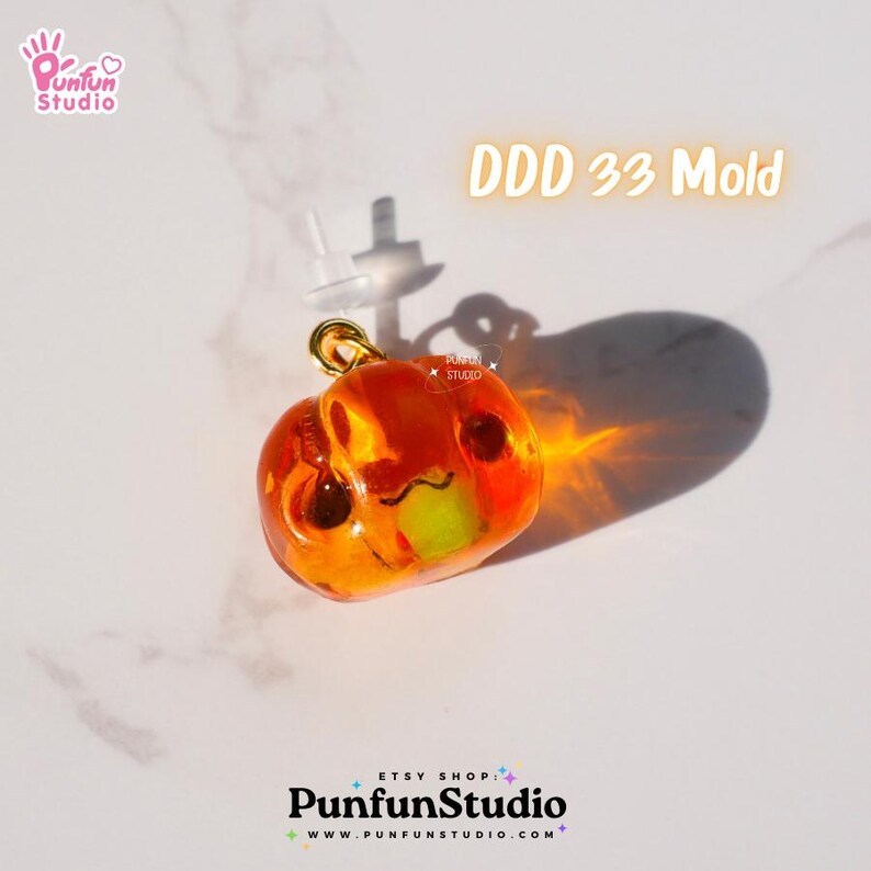 May include: Orange resin pumpkin charm with a cute face, attached to a gold earring post. DDD 33 Mold.