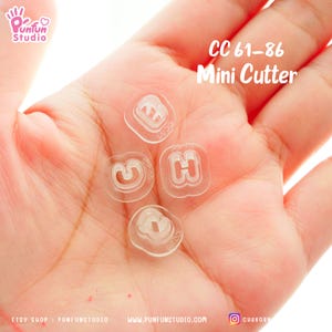May include: A set of clear plastic mini cutters shaped like the letters C, G, and H. The cutters are labelled "CC 61-86 Mini Cutter".