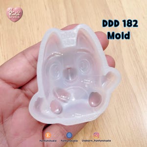 May include: A translucent silicone mold for crafting, featuring a recessed design of a cartoon character with large eyes, a small nose, and paws. The mold is embossed with the text DDD 182 Mold and Punfun Studio, with a heart logo in the corner.