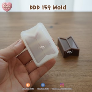 May include: A clear, rectangular mold with a geometric design is held in a hand. Next to it is a brown, solid resin casting of the same shape. The text "DDD 159 Mold" is displayed above the mold. The Punfun Studio logo is visible.