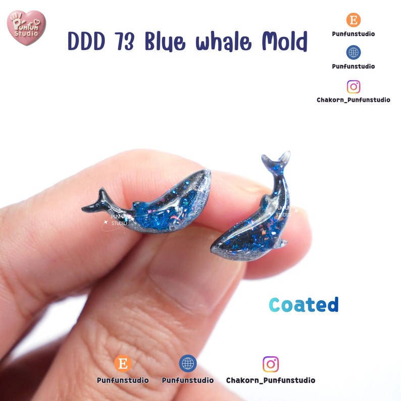 May include: Two blue whale molds with glitter accents. The molds are labeled "DDD 73 Blue whale Mold" and "Coated". The whales are held in a hand. The molds are for crafting.