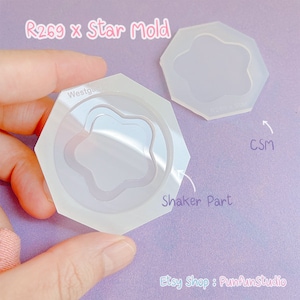 May include: Two clear silicone molds for resin crafts. The larger mold is a hexagon shape with a star-shaped cavity. The smaller mold is a hexagon shape with a star-shaped cavity and a smaller, concentric star-shaped cavity inside. The text "Shaker Part" is written on the image.