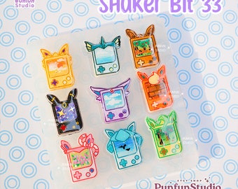 May include: A clear silicone mold with nine different designs of game consoles. Each console has a different color and design. The mold is labeled "Shaker Bit 33".