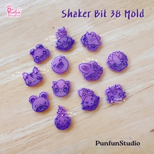 Puede incluir: Molde de bits de shaker morado con 12 diseños diferentes. Los diseños incluyen una rana, un gato, una flor, un unicornio y más. El molde está hecho de silicona transparente y es perfecto para hacer encantos de shaker de resina.
