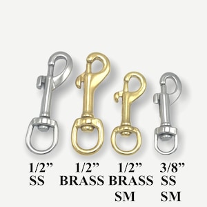 Op de afbeelding: Vier metalen gespen, twee in zilver en twee in goud. De gespen zijn 1/2 inch en 3/8 inch groot. De zilveren gespen zijn gemarkeerd met "SS" en de gouden gespen met "BRASS".