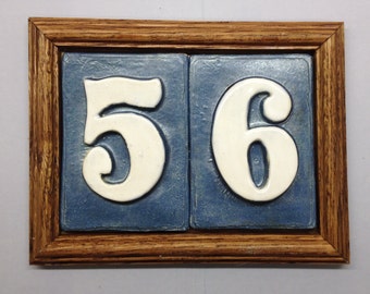 Address tiles in Oak frame plaque, multiple color choices available. PVc weatherproof backplate and concealed mounting.