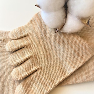 May include: A pair of beige toe socks with five individual toe compartments. The socks are made of a soft, breathable fabric and are designed to provide comfort and support.