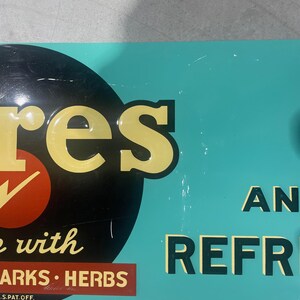 K&ouml;nnte beinhalten: Vintage Metallschild mit dem Wort "res" in gelben Buchstaben, einem roten Kreis mit einem wei&szlig;en H&auml;kchen und den Worten "with SPARKS HERBS" auf einem braunen Rechteck. Der Hintergrund ist t&uuml;rkis mit den Worten "AN REFR" in Schwarz.