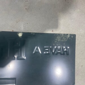 K&ouml;nnte beinhalten: Dunkelblaues Metallschild mit dem gepr&auml;gten Wort "HAVE" in Gro&szlig;buchstaben. Das Schild hat eine rechteckige Form mit einem leicht abgenutzten Aussehen, das Gebrauchsspuren aufweist.