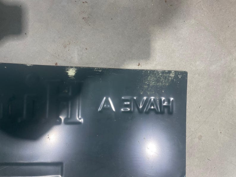 K&ouml;nnte beinhalten: Dunkelblaues Metallschild mit dem gepr&auml;gten Wort "HAVE" in Gro&szlig;buchstaben. Das Schild hat eine rechteckige Form mit einem leicht abgenutzten Aussehen, das Gebrauchsspuren aufweist.