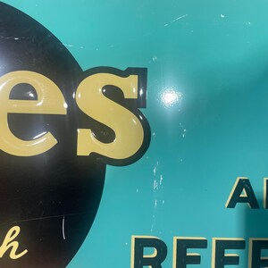 K&ouml;nnte beinhalten: Ein Schild im Vintage-Stil mit dem Wort "es" in Gelb, schwarz umrandet, auf schwarzem Hintergrund. Das Schild hat einen t&uuml;rkisfarbenen Hintergrund mit dem Wort "AND" in Schwarz. Das Schild hat einen roten Kreis mit einer wei&szlig;en Linie.
