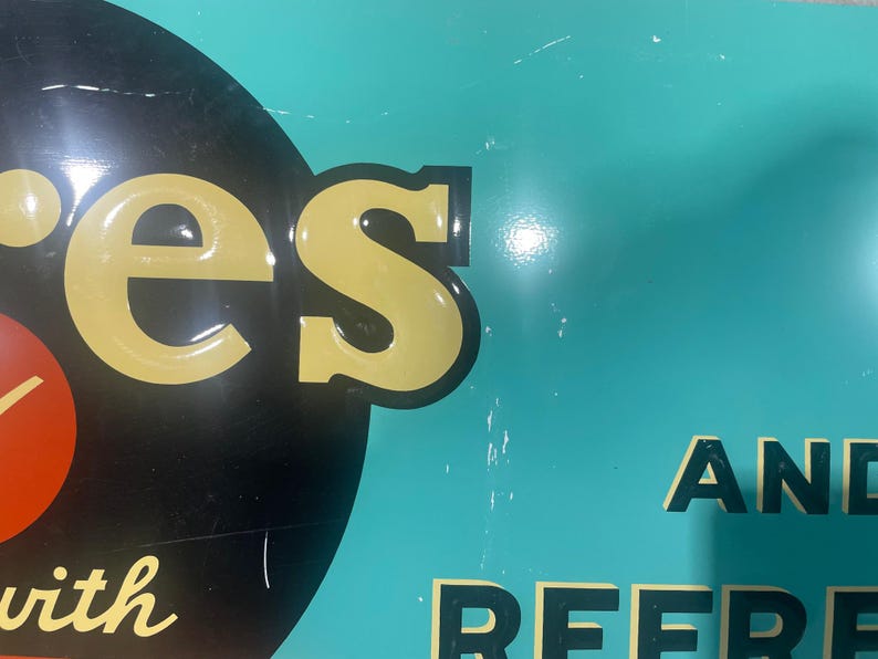K&ouml;nnte beinhalten: Ein Schild im Vintage-Stil mit dem Wort "es" in Gelb, schwarz umrandet, auf schwarzem Hintergrund. Das Schild hat einen t&uuml;rkisfarbenen Hintergrund mit dem Wort "AND" in Schwarz. Das Schild hat einen roten Kreis mit einer wei&szlig;en Linie.