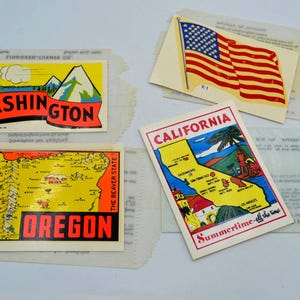 May include: A collection of vintage travel stickers featuring state maps and the American flag. The stickers showcase the states of Washington, Oregon, and California, with vibrant colors and retro designs. The California sticker reads "Summertime - all the time."